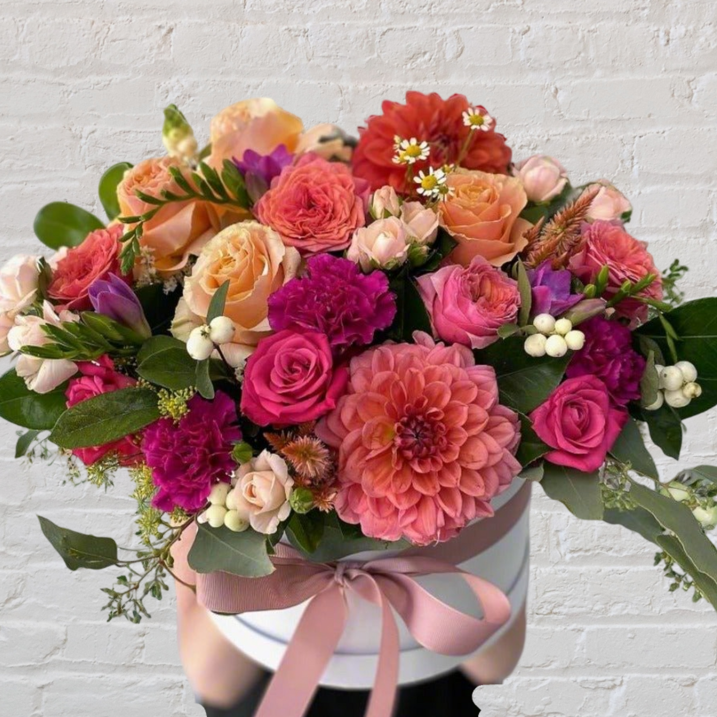 Seasonal flowers arranged into a round hatbox