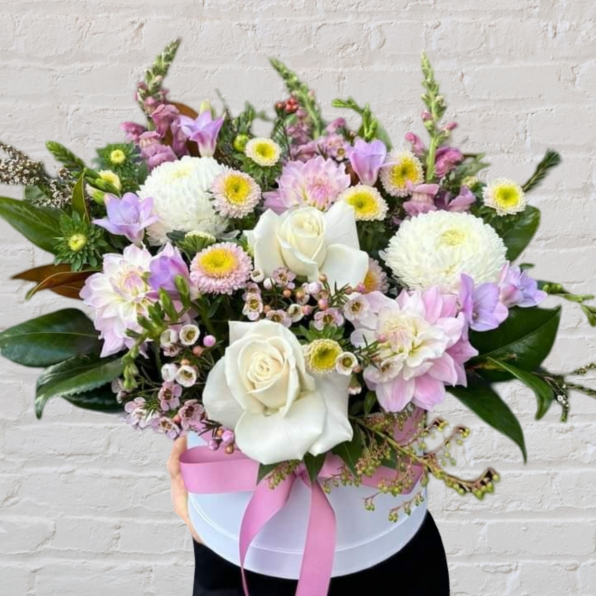 Seasonal pastel flowers in a hatbox